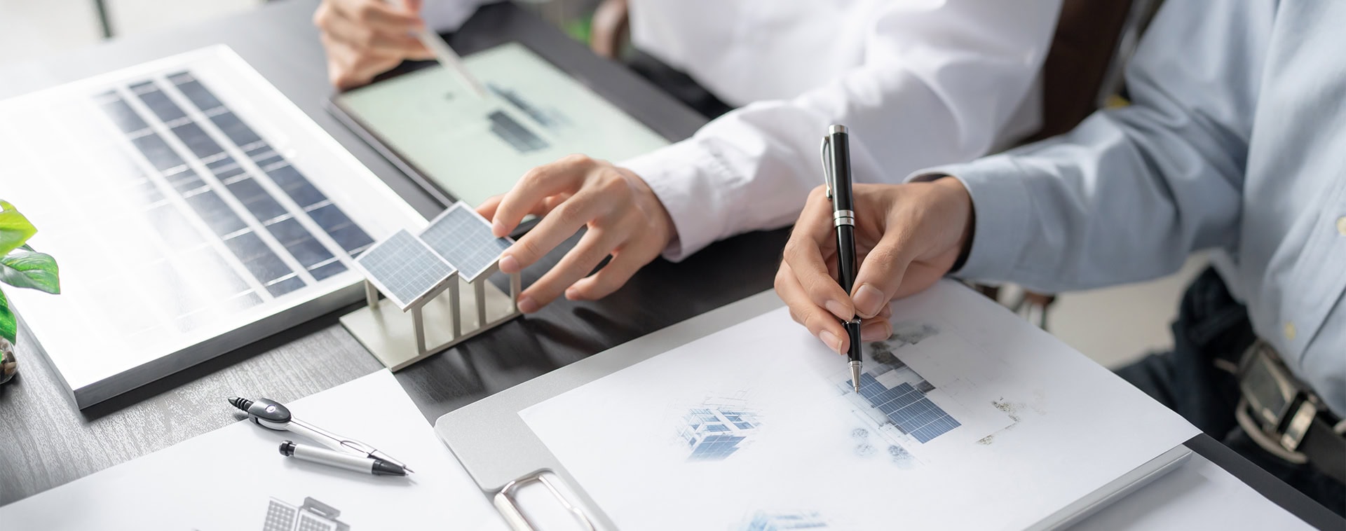 Person arbeitet mit Solarenergie-Diagrammen am Tisch